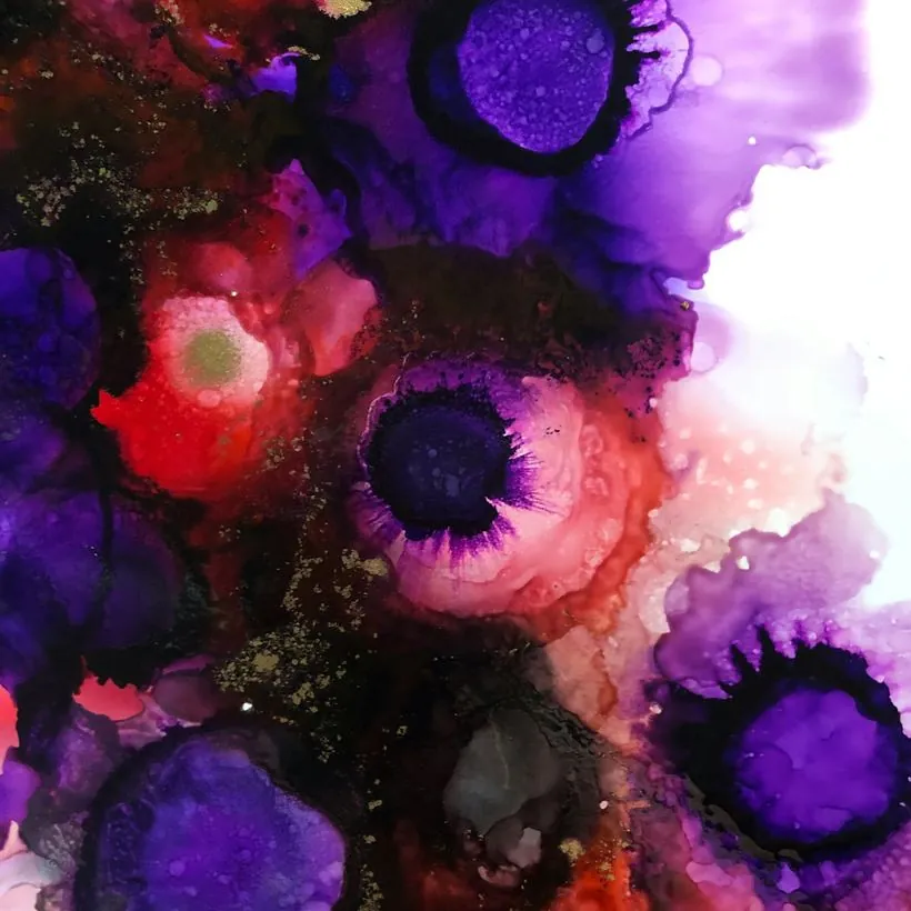 Purple and crimson alcohol inks blooming into each other, flecked with gold